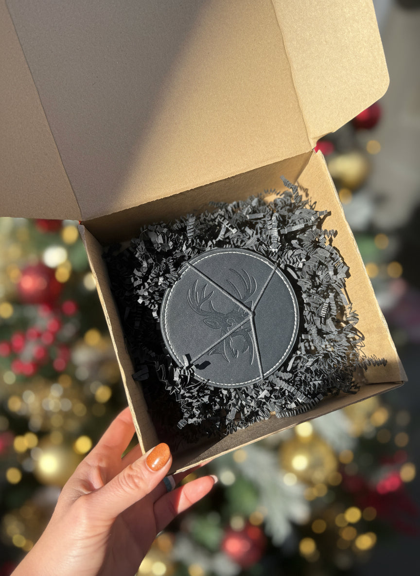 Hand holding a box with a circular black patch featuring a logo.