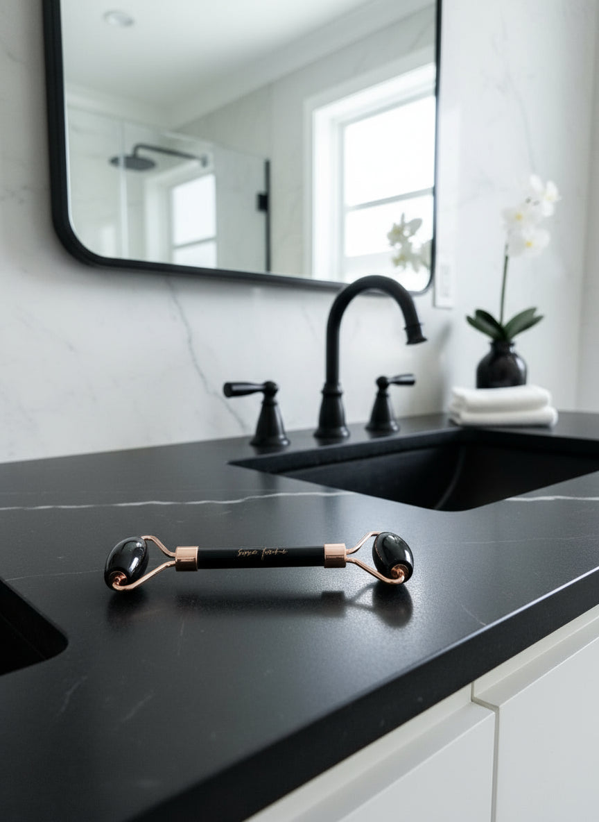 Facial roller with black stones on a wooden surface