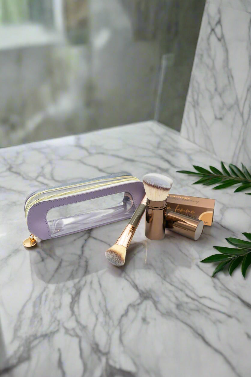 Makeup brushes with a clear and purple case on a light gray background