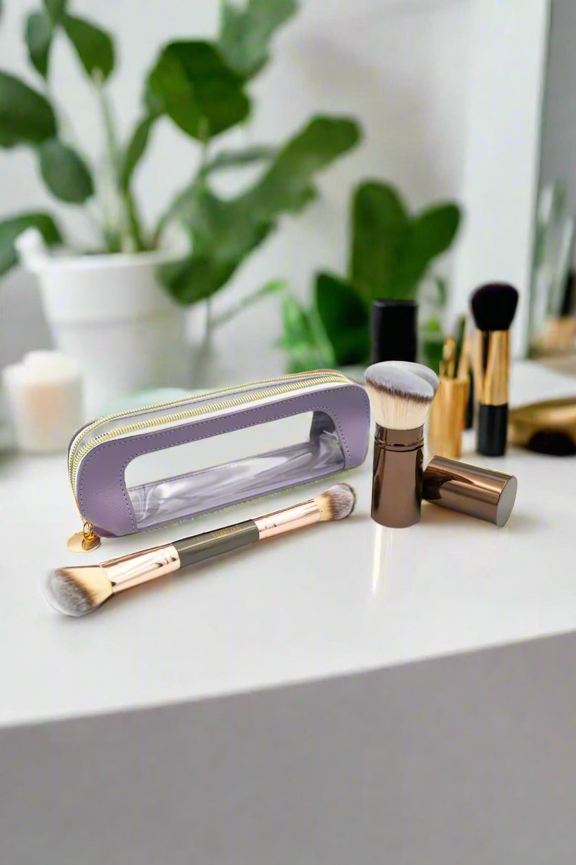 Makeup brushes and a purple case on a light gray background
