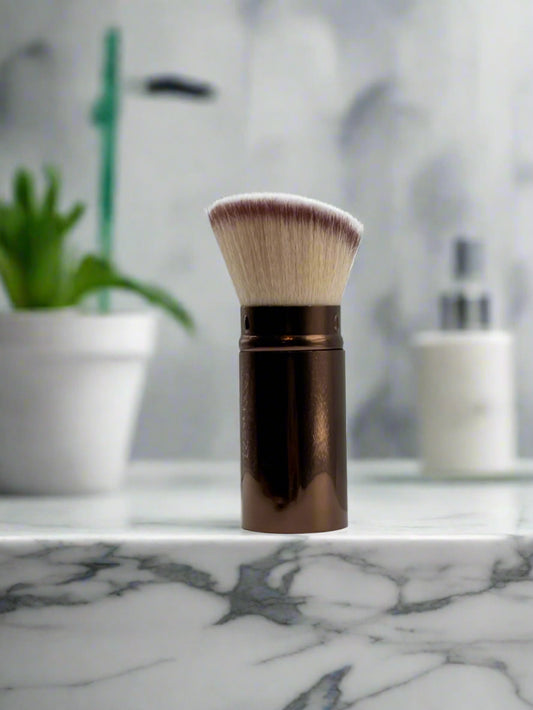 Makeup brush with brown handle on a white surface